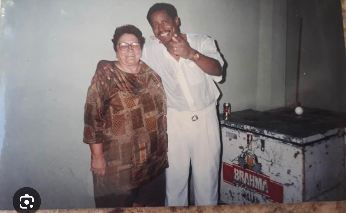 Dona Mocinha ao lado de um músico em registro histórico