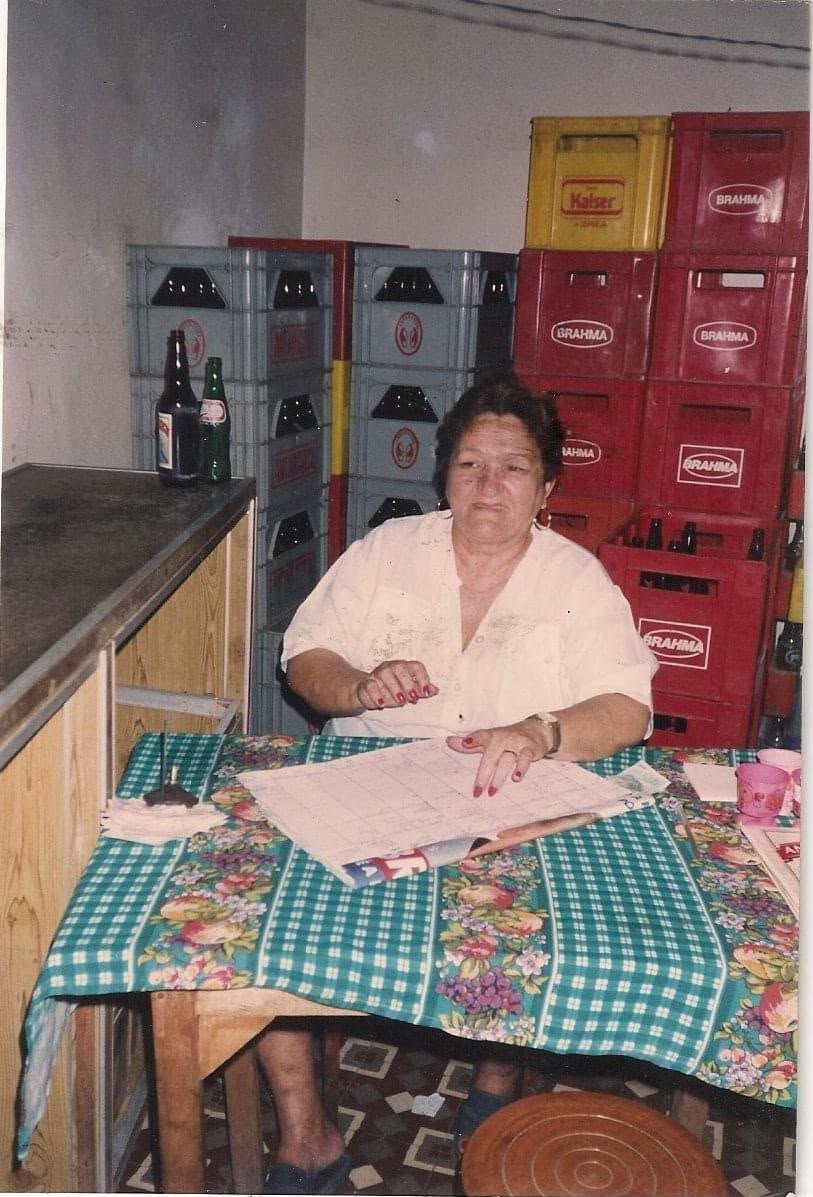 Dona Mocinha sentada no Bar da Mocinha