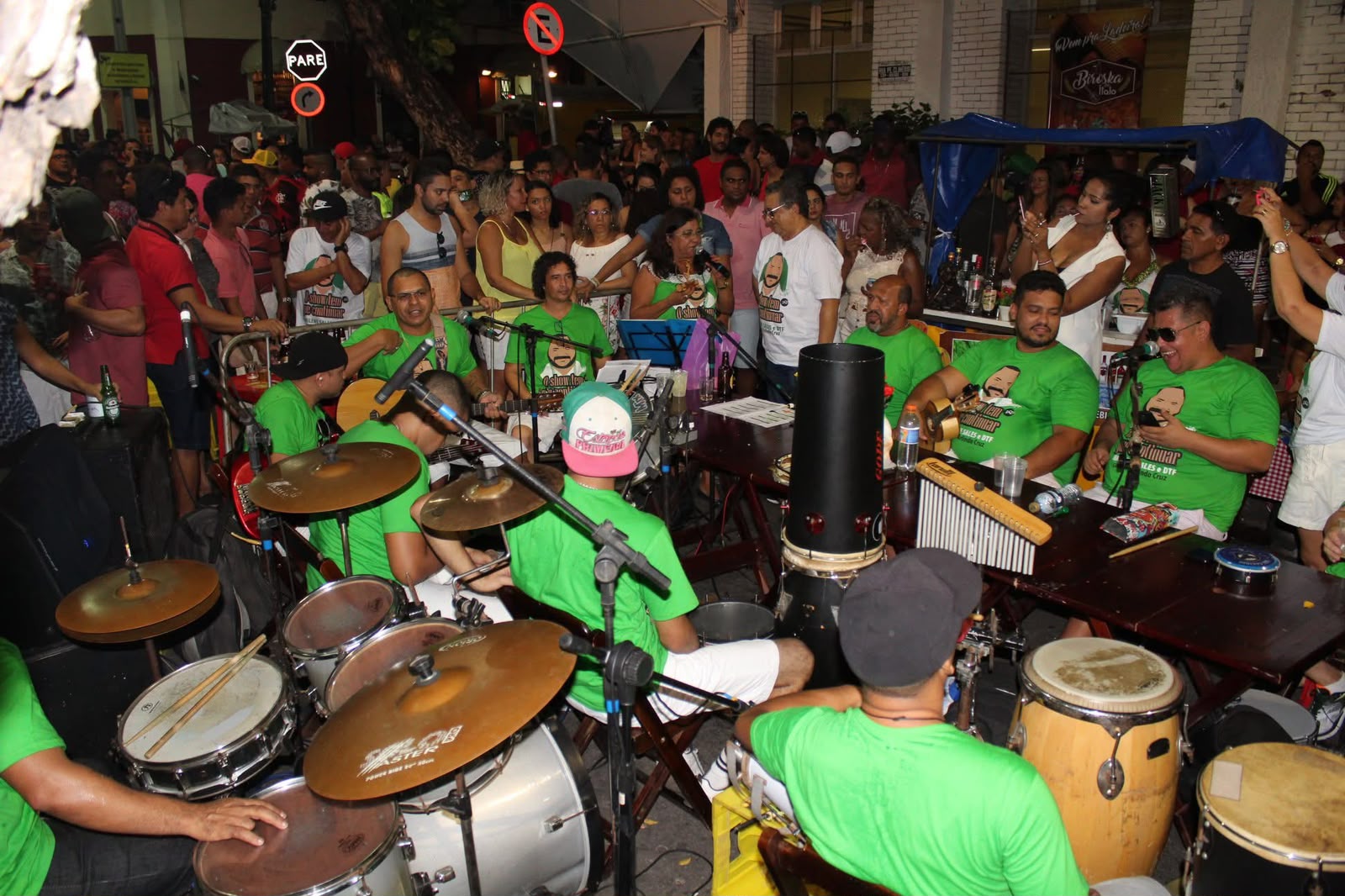 Grupo de músicos vestidos de verde tocando samba